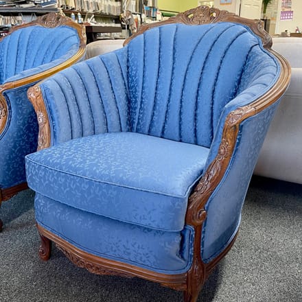 Chair reupholstered with blue fabric and vertical channels on the back and arms